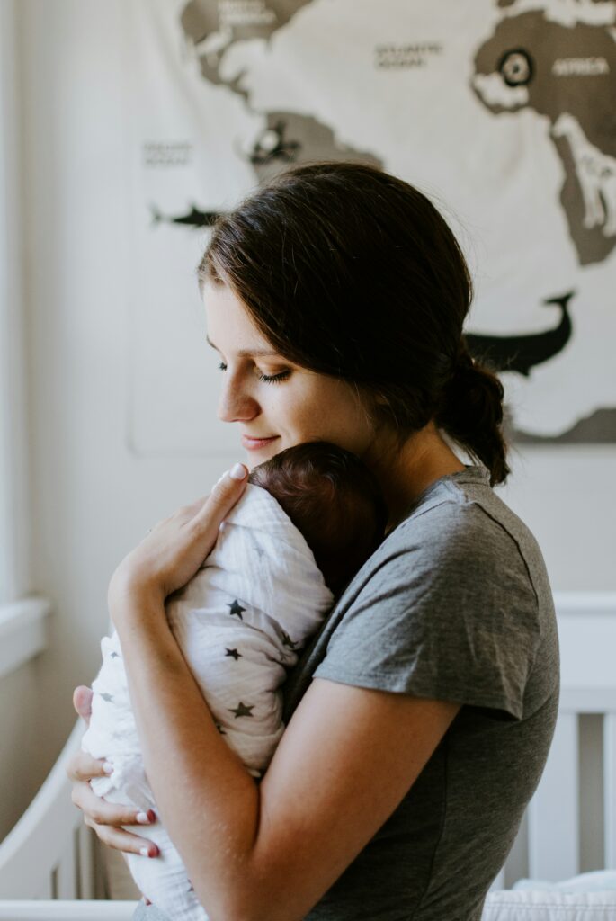 mother holding baby in a swaddle